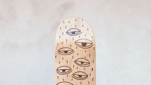 Abschnitt eines Skateboard Decks mit schlichten schwarzen Illustrationen von Augen.