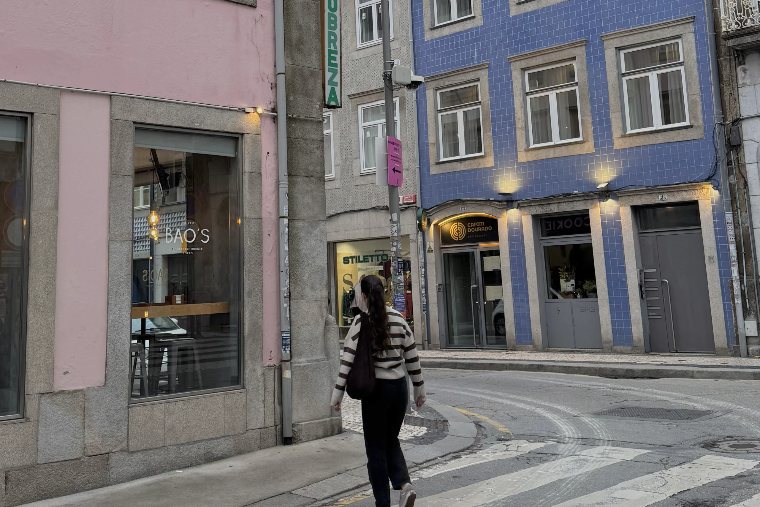 Foto von Jana Hiller auf einem Zebrastreifen zwischen bunten Hรคusern.