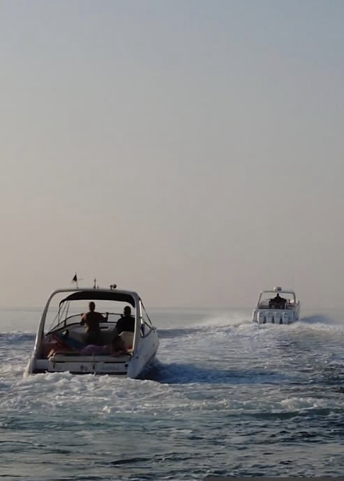 Fotografie zweier Sportboote auf dem Wasser im frühen Morgenlicht.